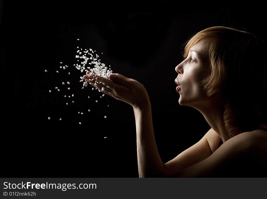 Beautiful woman blowing white fluff. Beautiful woman blowing white fluff