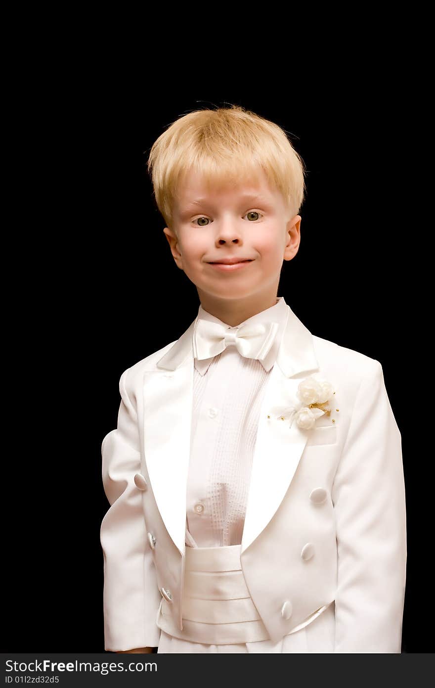 The child in a white tuxedo on a black background