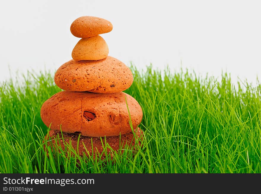 Pyramid of red cobble-stones in the green grass. Pyramid of red cobble-stones in the green grass