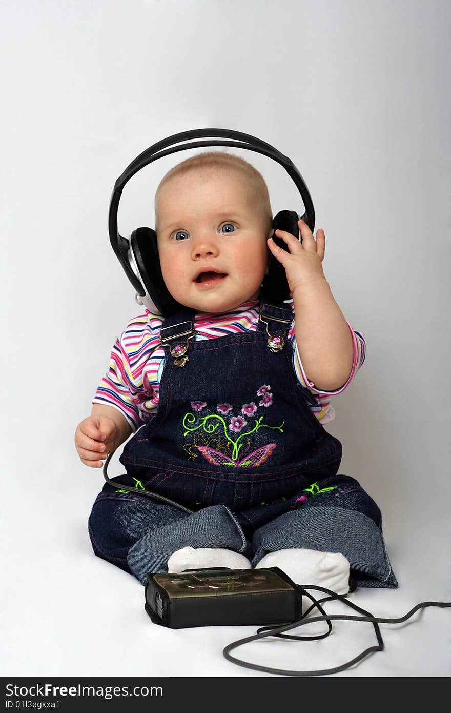 Little girl listen music in big headphones