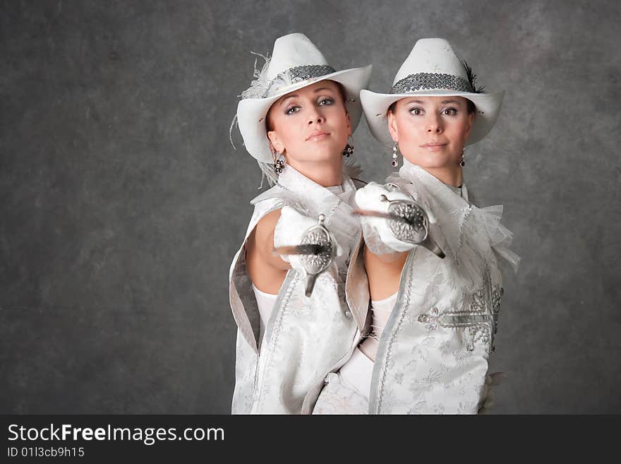 Beautiful girls in suits of musketeers