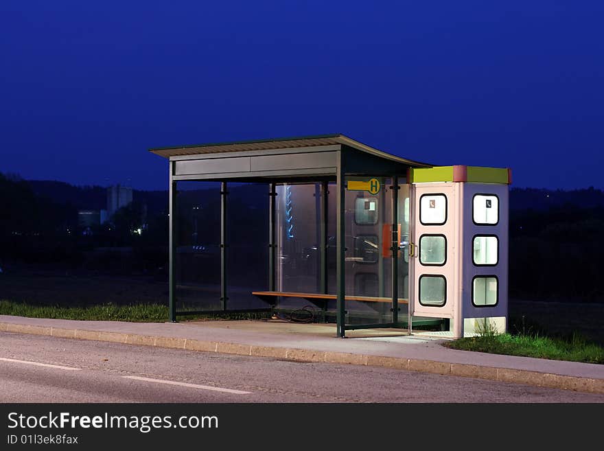 Bus stop with telephone booth at dusk. Bus stop with telephone booth at dusk