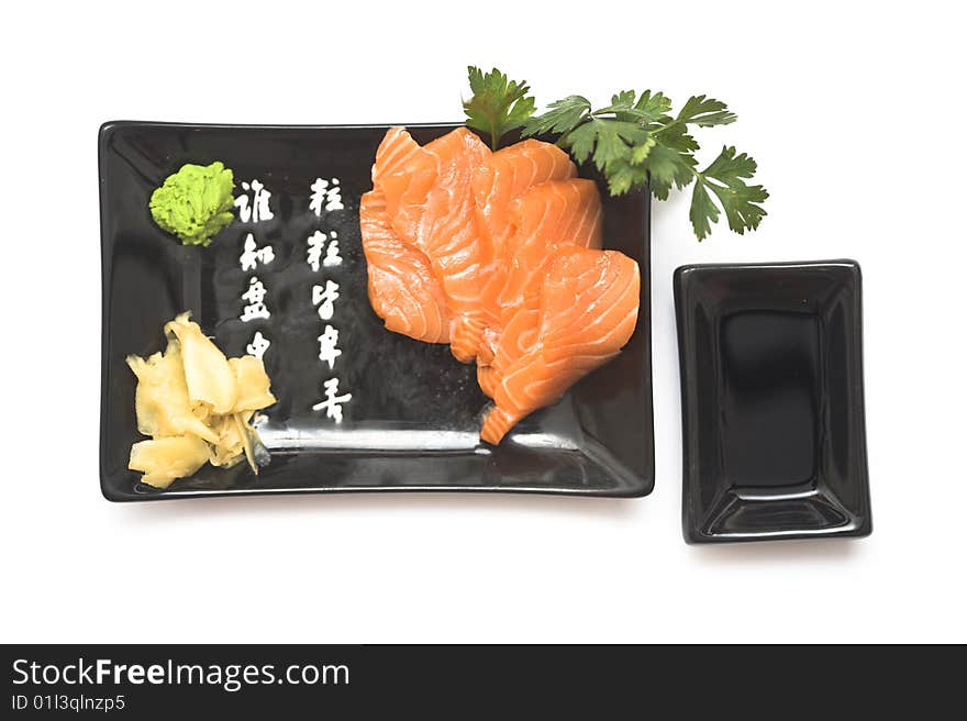 A set of sushi on a black plate with wasabi and gari, isolated on a white background. A set of sushi on a black plate with wasabi and gari, isolated on a white background.