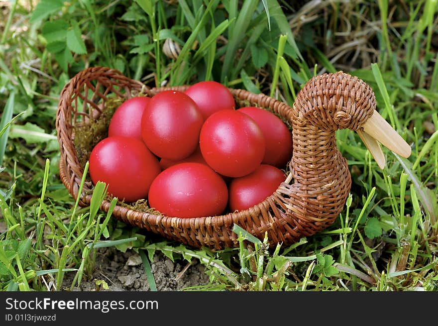 Red easter eggs in duck shaped basket