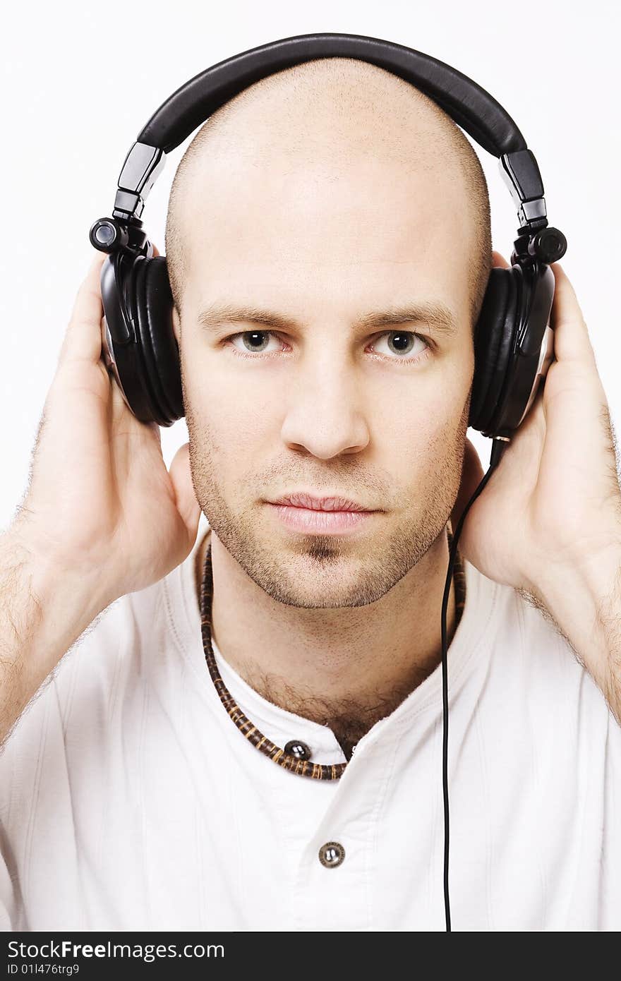 Young man wearing headphones - with hands on the headphones. Young man wearing headphones - with hands on the headphones