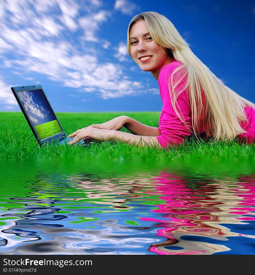 Beautiful girl with laptop on the blue sky and green grass background. Beautiful girl with laptop on the blue sky and green grass background