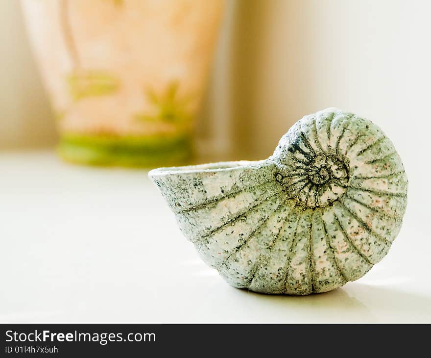 Crafted Seashell on a white ledge in a modern, luxurious Bathroom. Crafted Seashell on a white ledge in a modern, luxurious Bathroom.