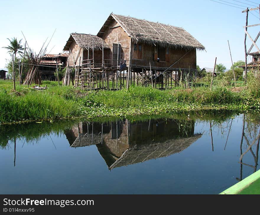 Fishing hut reflection in lake water.