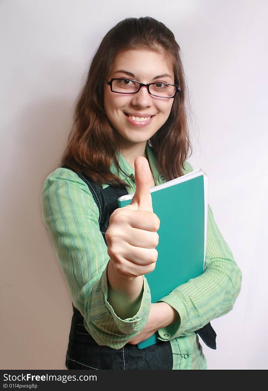 The image of the girl with the hand extended forward and lifted upwards thumb. The image of the girl with the hand extended forward and lifted upwards thumb.