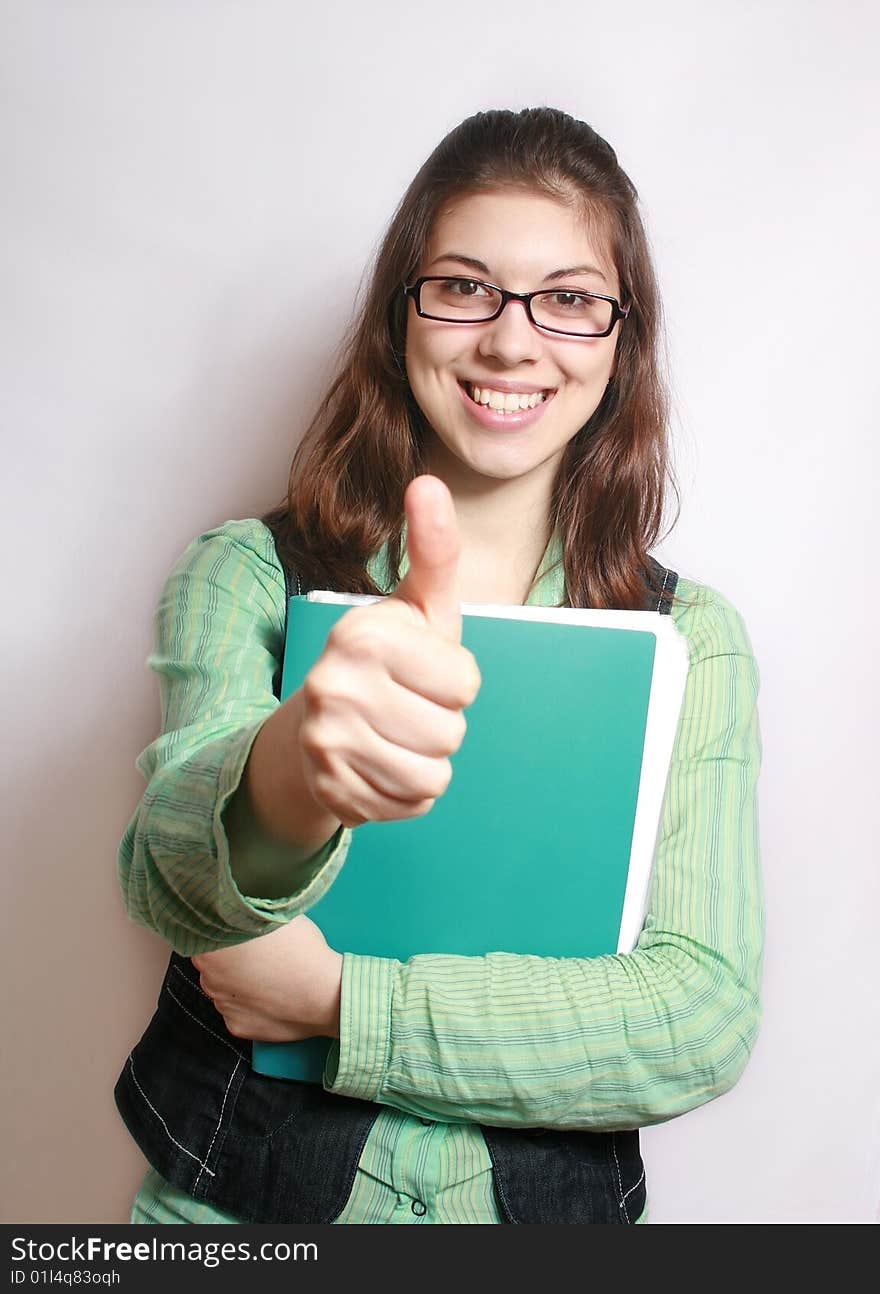 The image of the girl with the hand extended forward and lifted upwards thumb. The image of the girl with the hand extended forward and lifted upwards thumb.