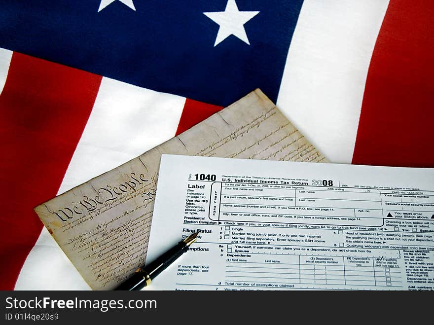 The U.S. Constitution and tax form on an American flag. The U.S. Constitution and tax form on an American flag.