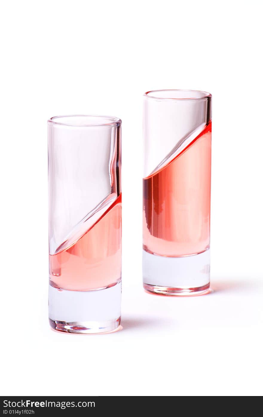 Thin glasses with pink liquid on white background