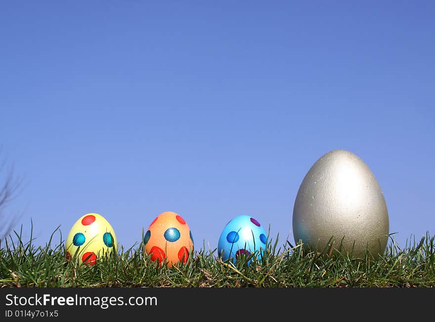 Easter eggs in grass against  a bright blue sky