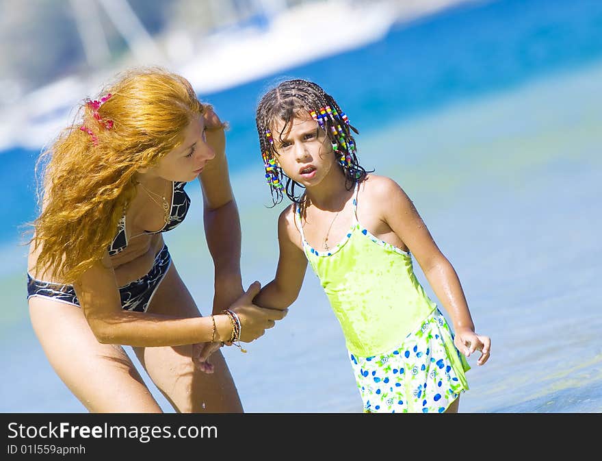 Portrait of young woman with her daughter on beach. Portrait of young woman with her daughter on beach