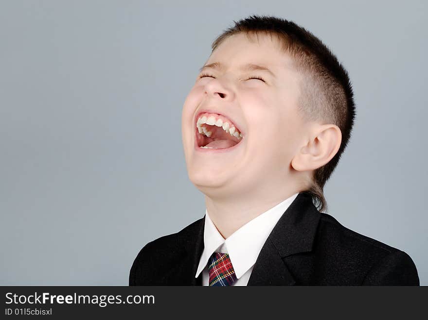 Laughing boy in a jacket and tie