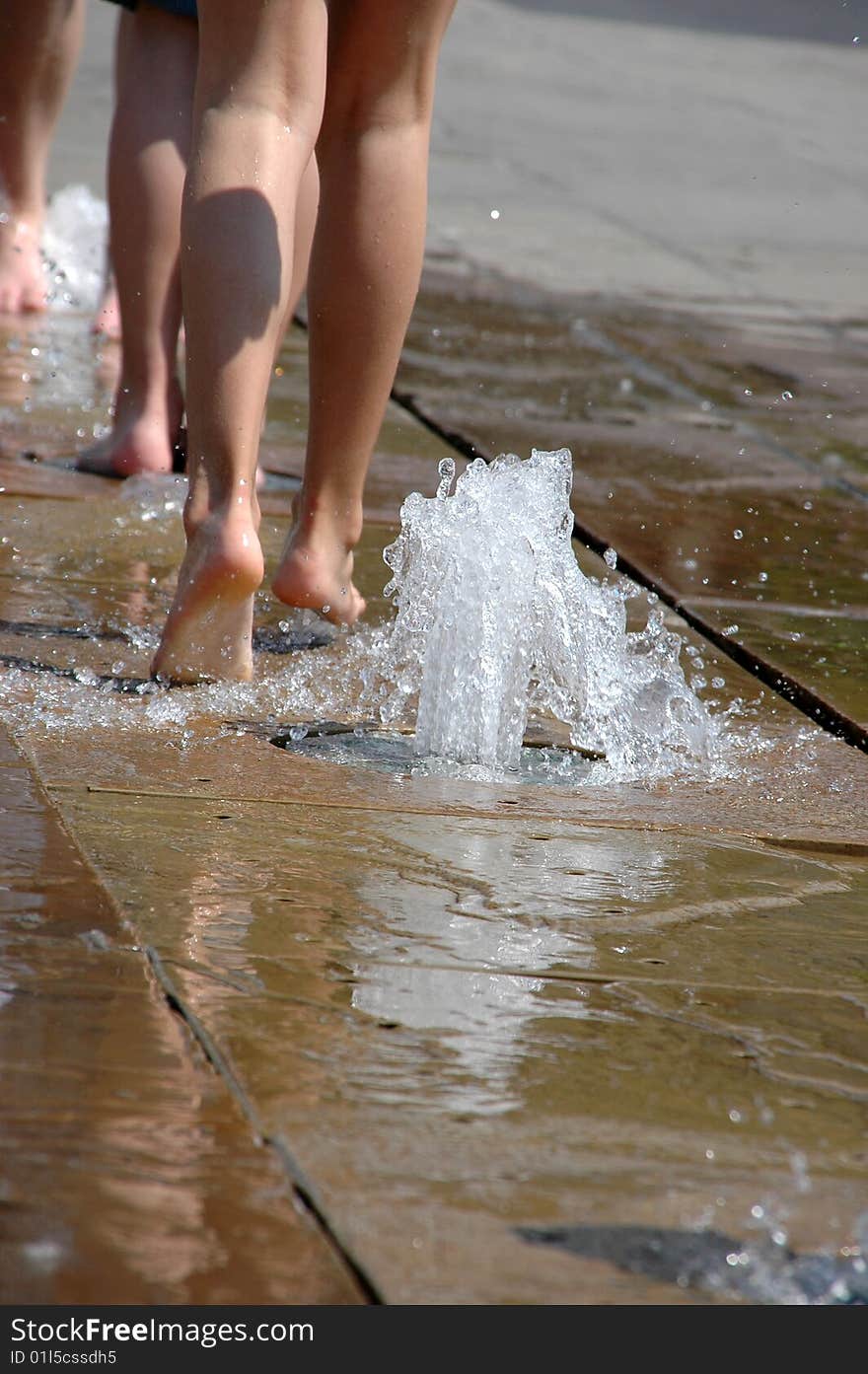 Naked feet running through a fountain. Naked feet running through a fountain