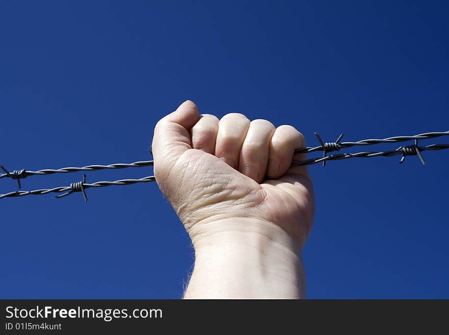 Fist holding round a barbed wire