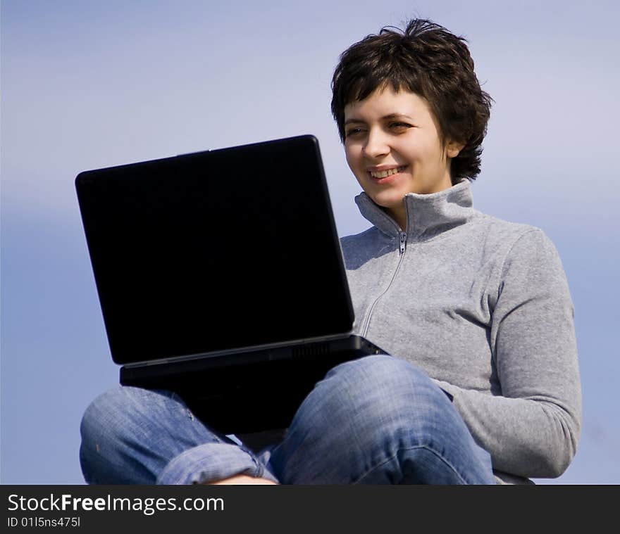 Young casual woman working on laptop