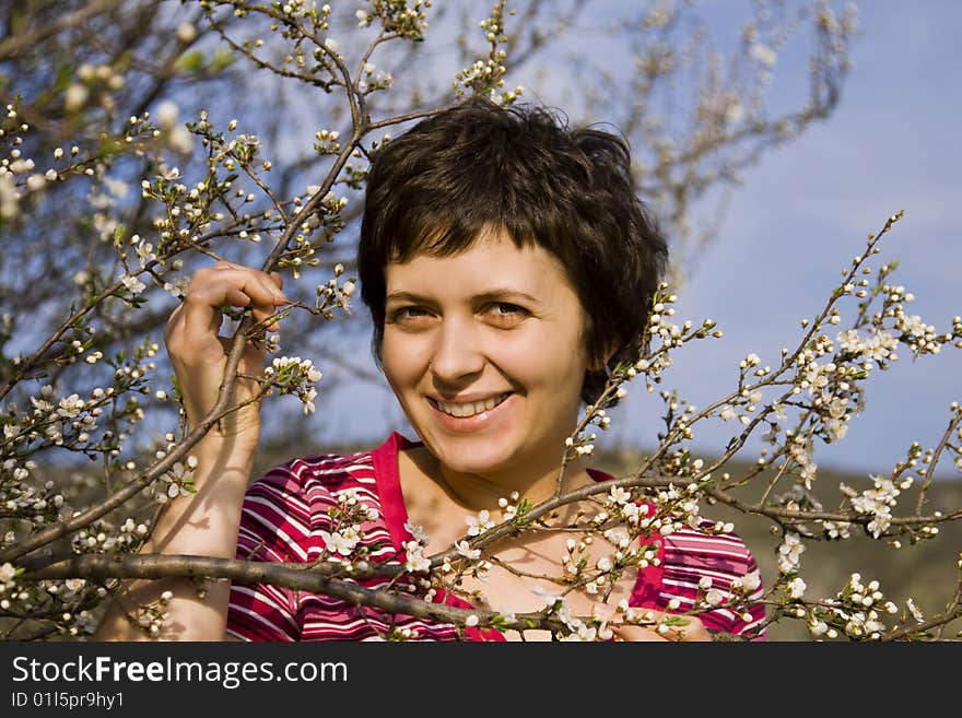 Beautiful young woman amongst spring blossom