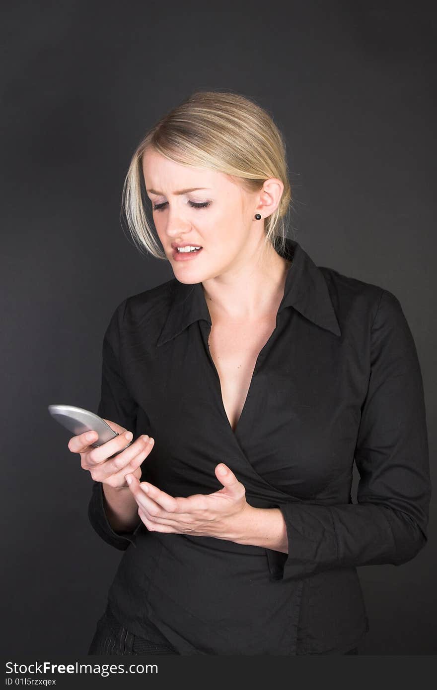 Angry Businesswoman looking at her cordless phone. Angry Businesswoman looking at her cordless phone