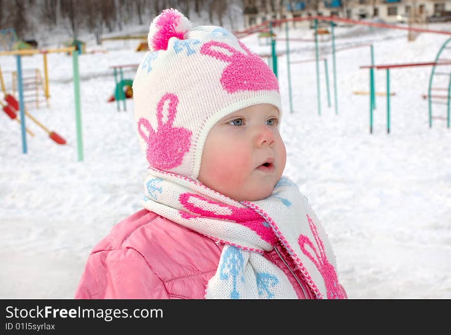 Little girl on winter playground.