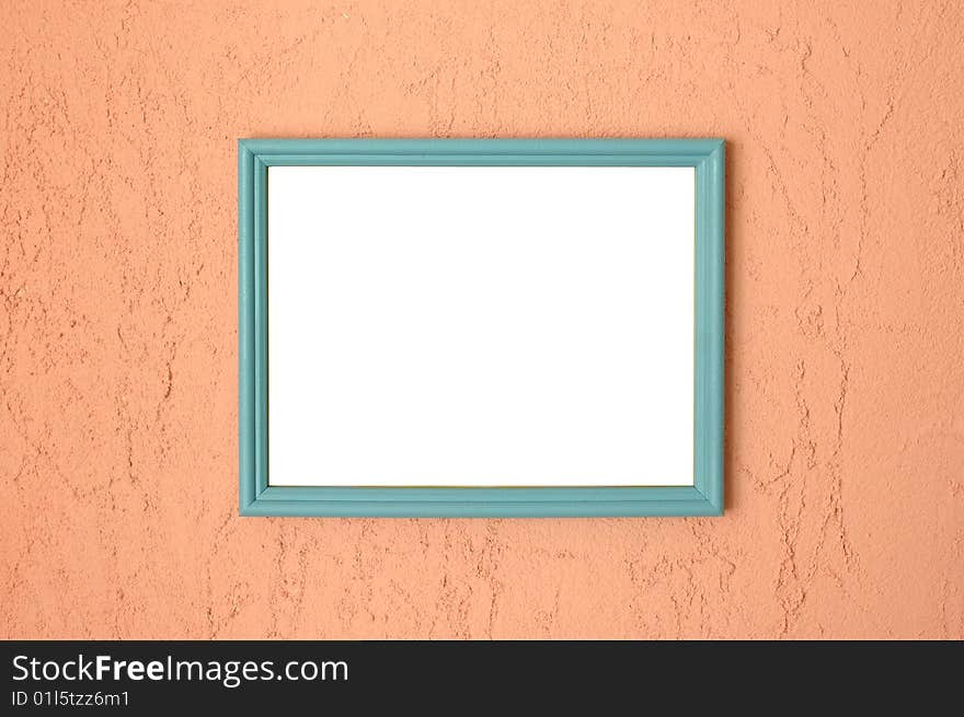 Photo frame on brightly coloured pink stucco wall.