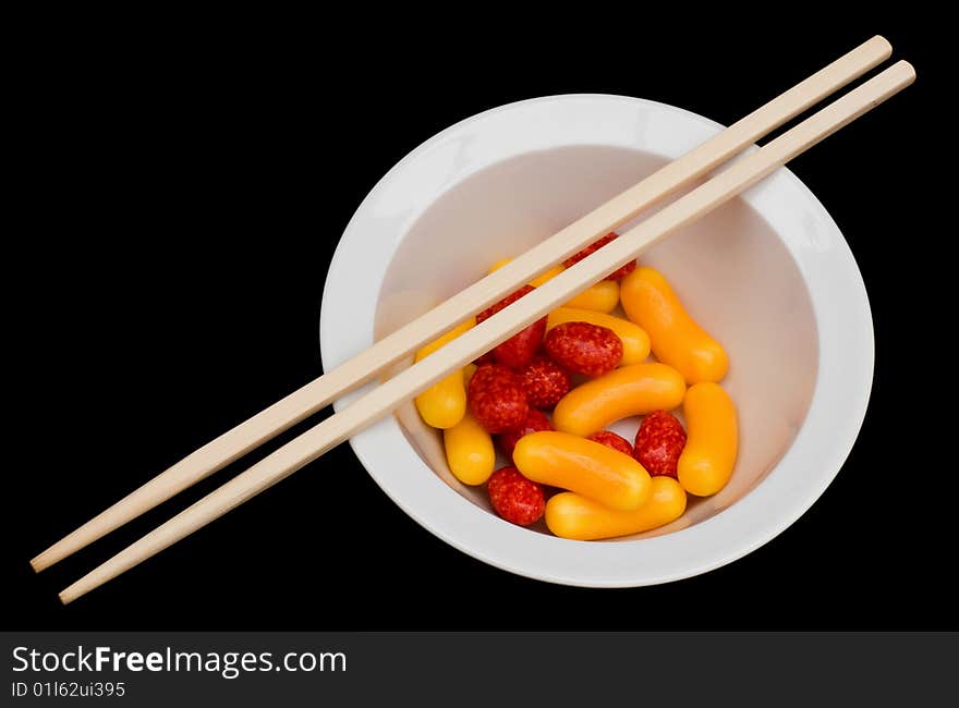 Colorful candy in a white bowl isolated and some chopsticks