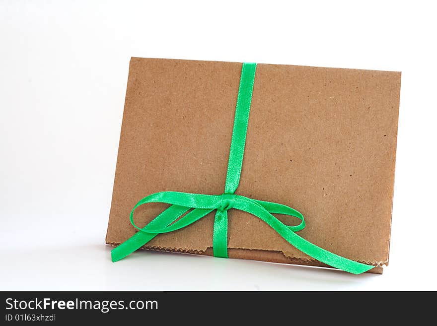 Concept for earth day recycled brown paper bag wrapped in green ribbon