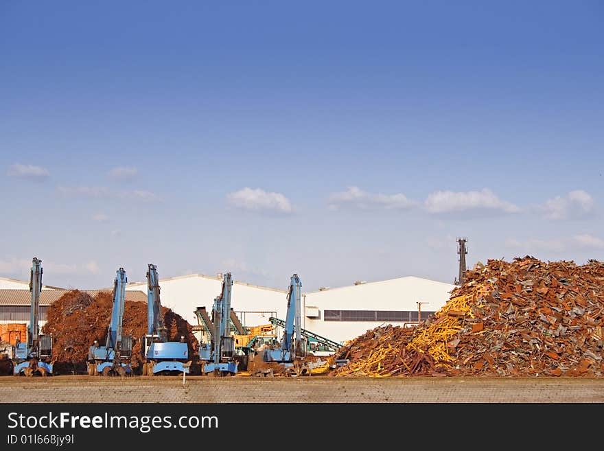 A typical junkyard in front of a shiny blue sky. A typical junkyard in front of a shiny blue sky.