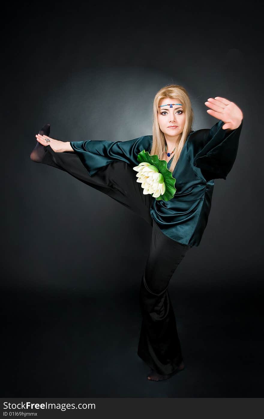 Woman with lotus flower exercising, studio shot