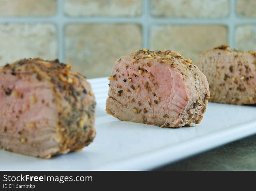 Sliced pork tenderloin on plate with focus on center piece