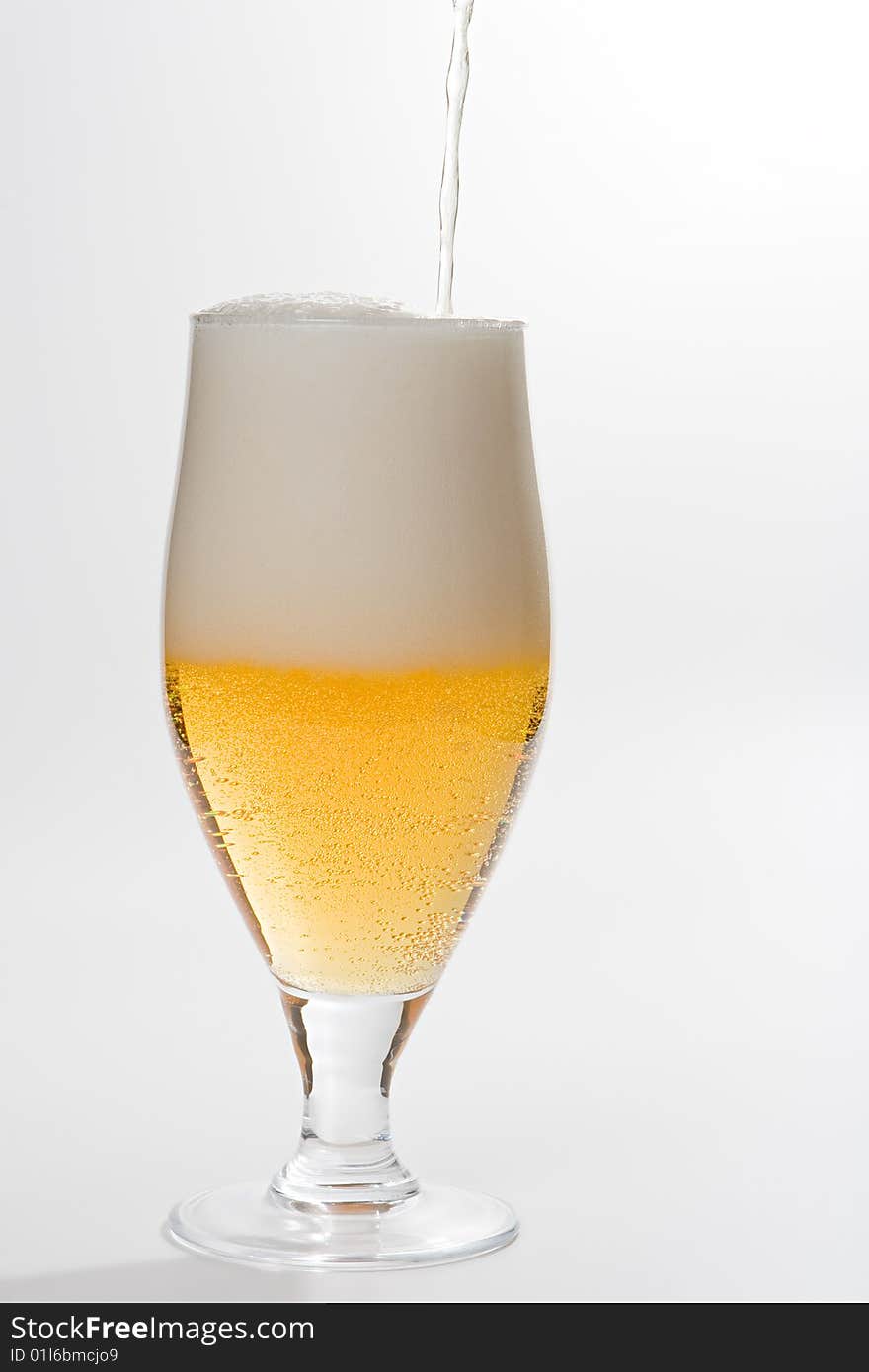 Glass with poured beer isolated on white background