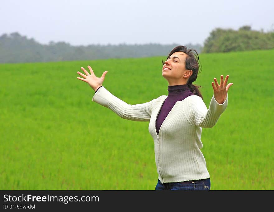 Beautiful girl looks happy in a green field. Beautiful girl looks happy in a green field.