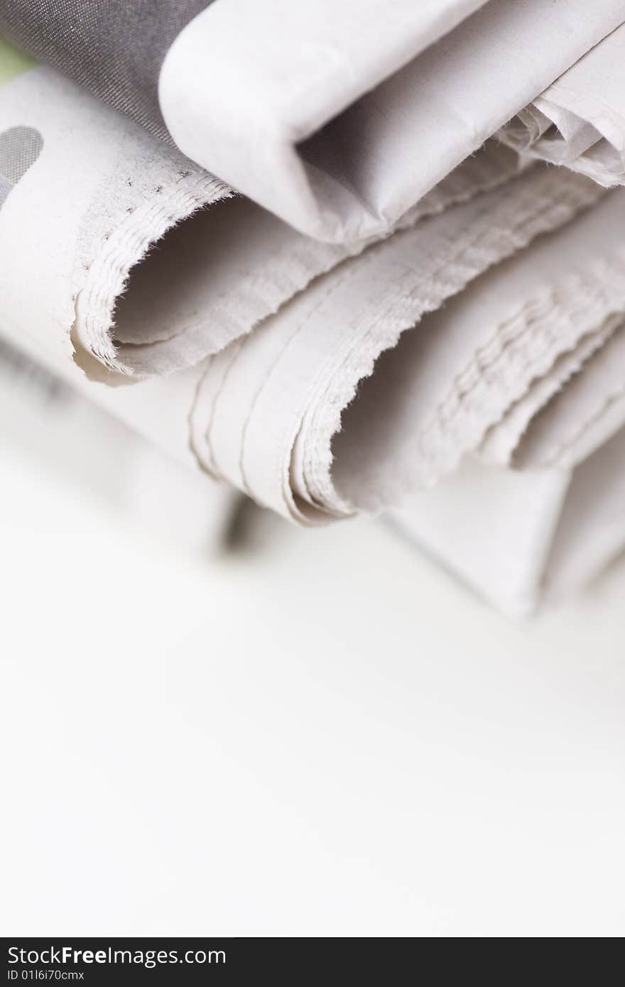 Pile of newspapers on white table