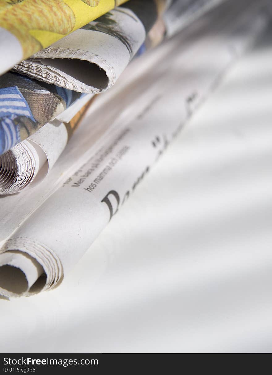 Pile of newspapers on white table