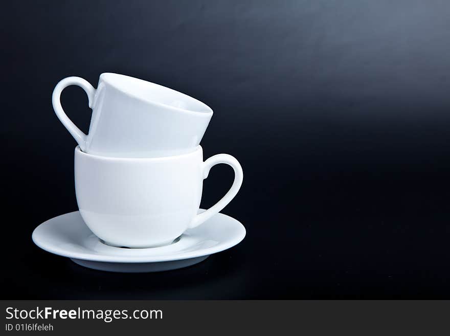 Two cups of white on a black