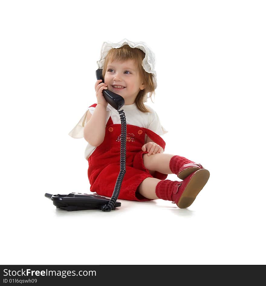 Little girl speaks on the phone. Studio shot