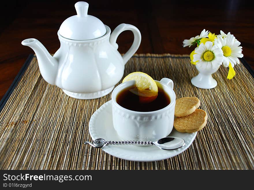 A fresh hot cup of tea with lemon and cookies