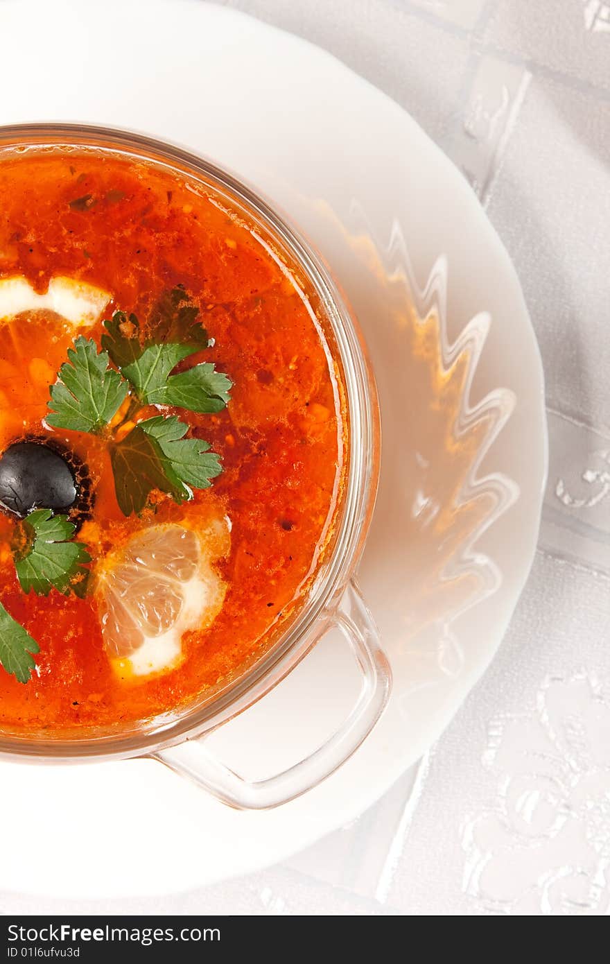 Delicious red soup in a glass bowl over white