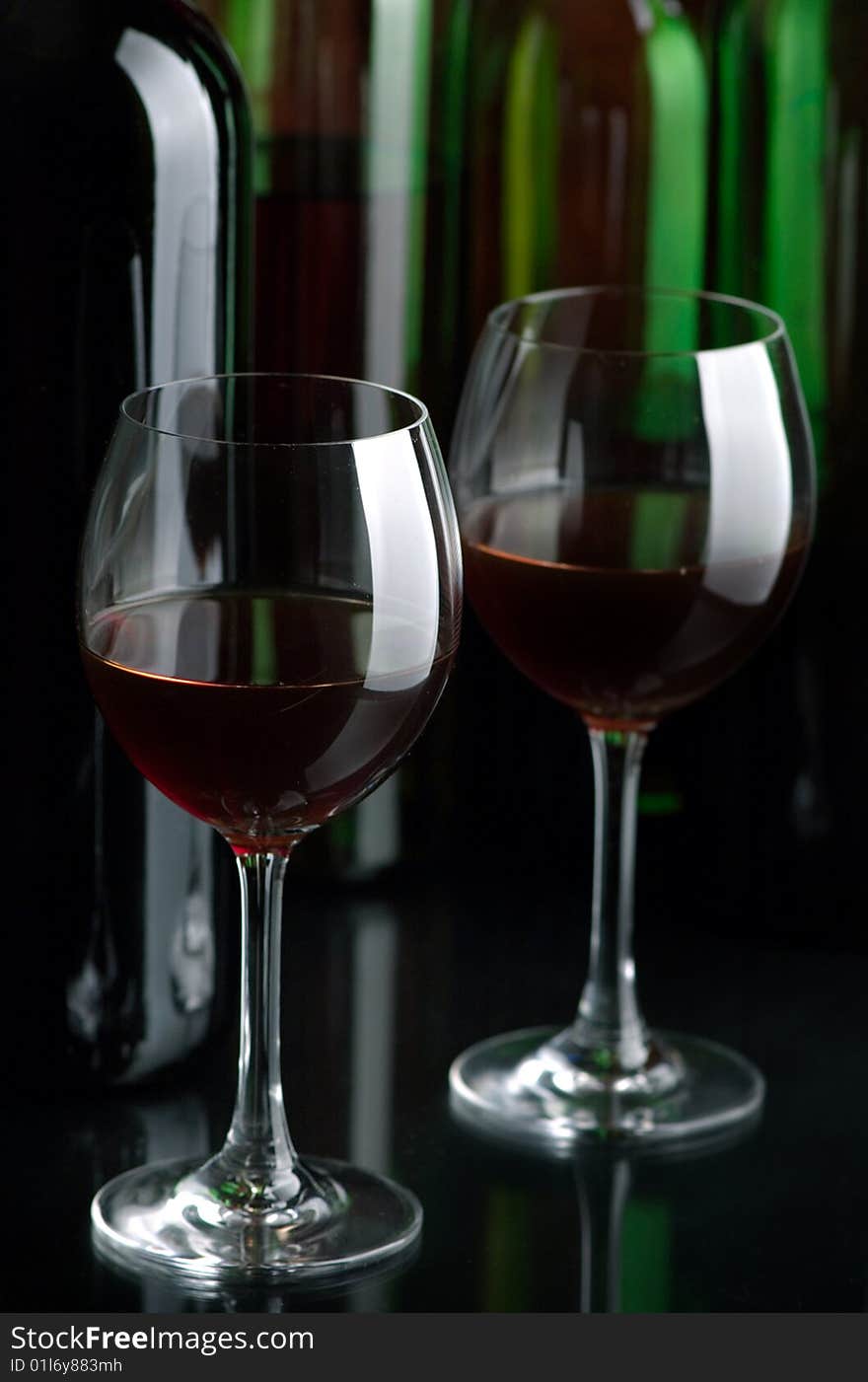 Bottles and glasses of excellent wine on a dark background. Bottles and glasses of excellent wine on a dark background