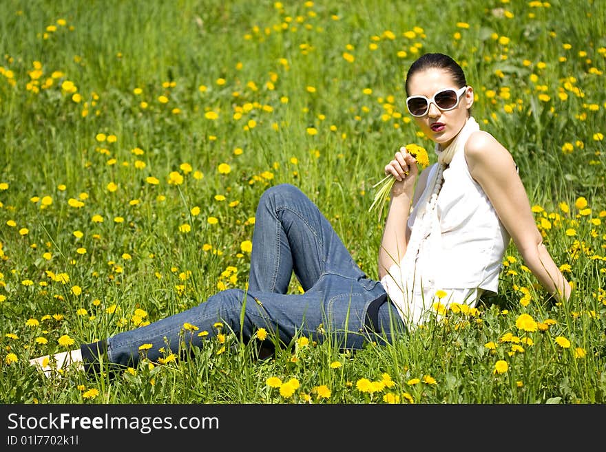 Young Woman In Nature Smelling A Flower