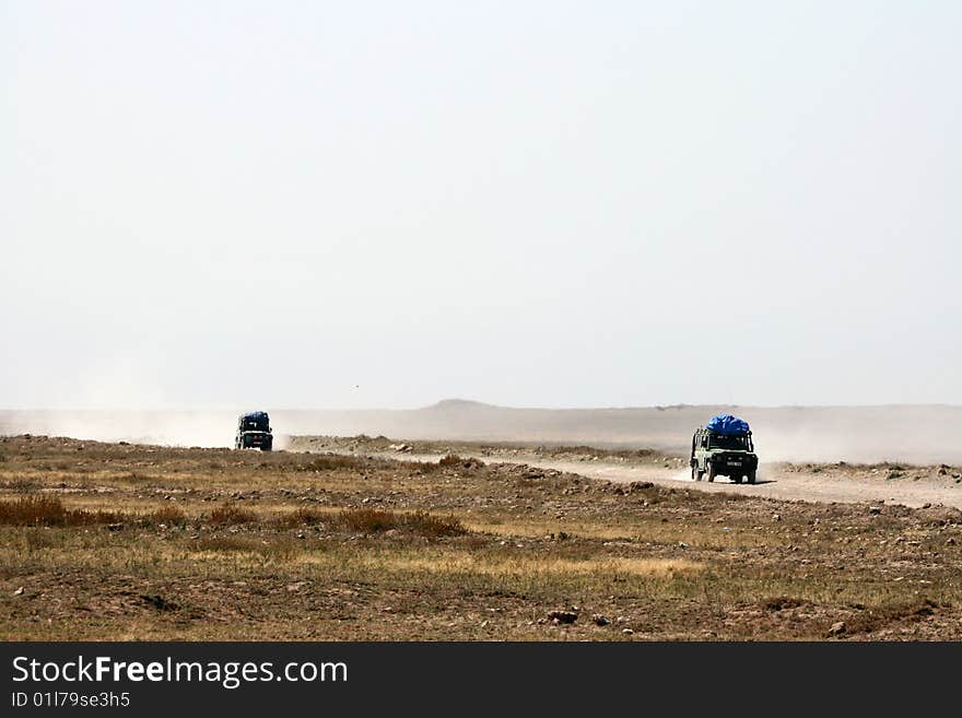 Safari 4WD cars on a dusty road from Ngorongoro crater to Serengeti National Park, Tanzania