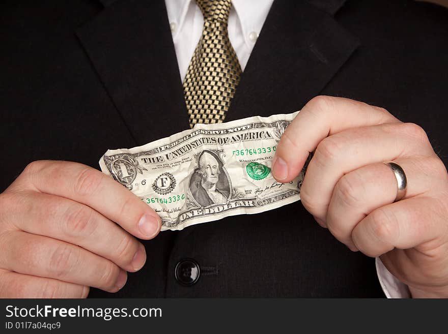 Businessman in a Suit and Tie Holding Wrinkled United States Dollar Bill. Businessman in a Suit and Tie Holding Wrinkled United States Dollar Bill.