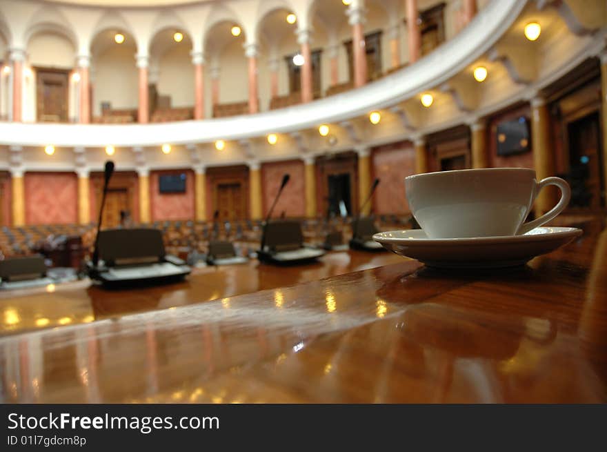 Cup of coffee in empty conference room, coffee break