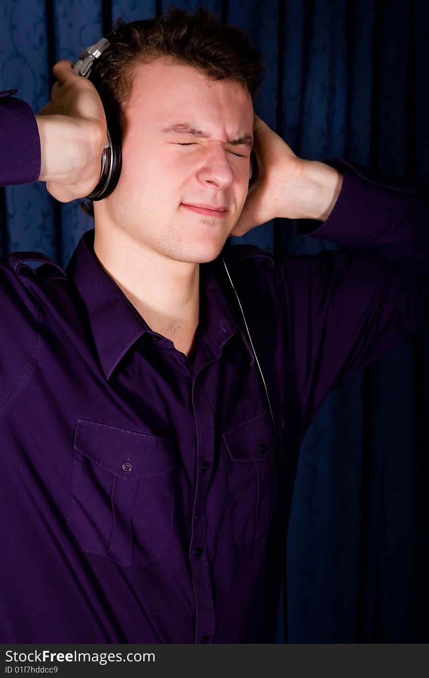 Close up portrait of young man with headphones indoors. Close up portrait of young man with headphones indoors