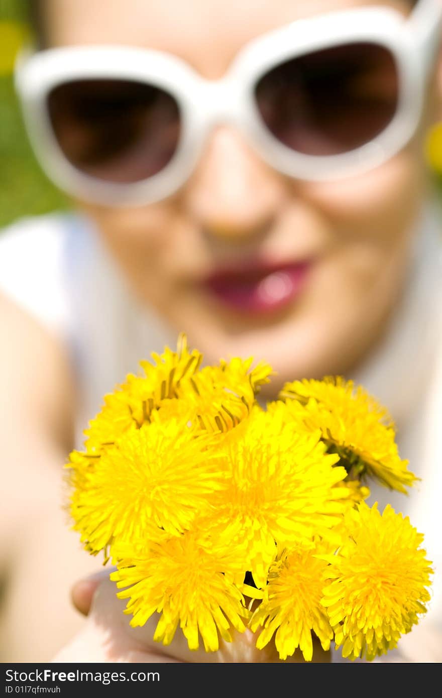 Young woman in nature offering flowers