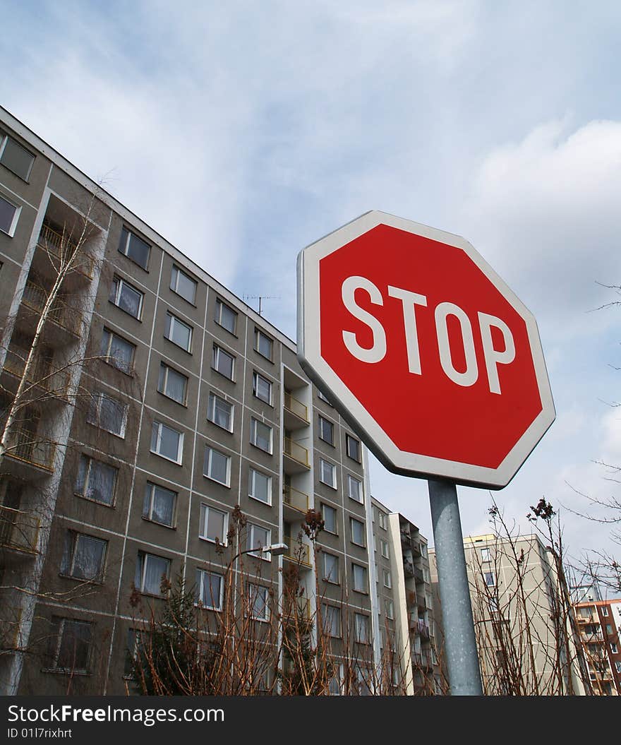 Octagonal stop traffic sign and block of flats