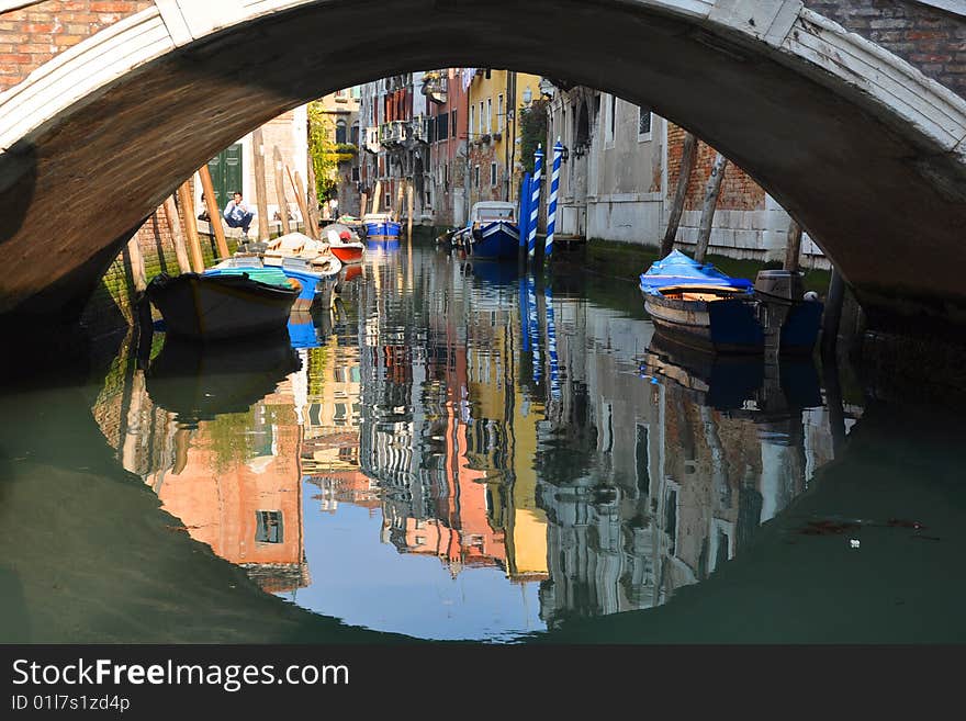 The colored house of venice reflex in the canal under the bridge