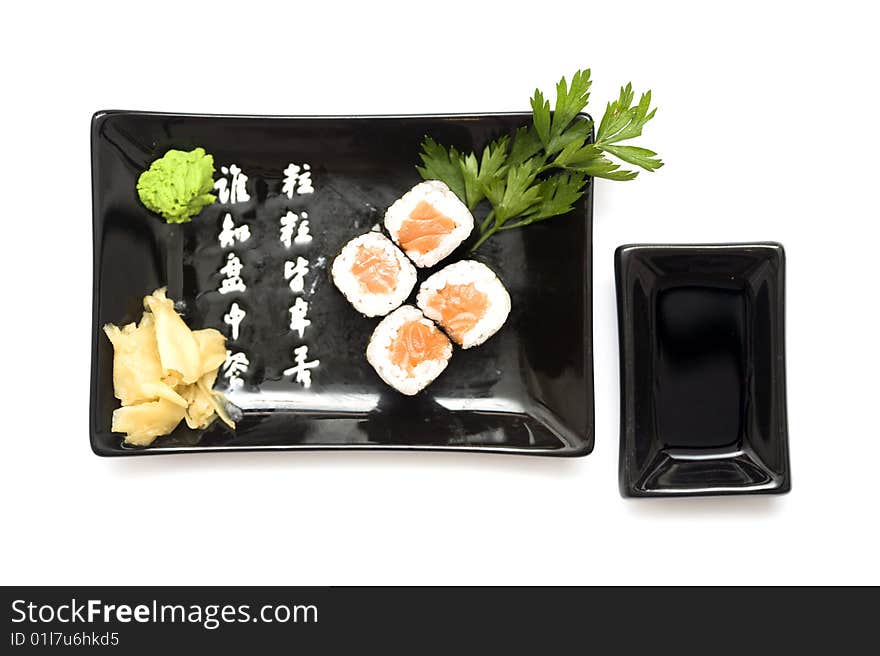 A set of sushi on a black plate with wasabi and gari, isolated on a white background. A set of sushi on a black plate with wasabi and gari, isolated on a white background.