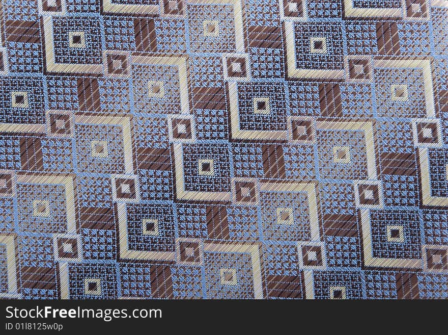 Textile background with blue, brown and golden shapes